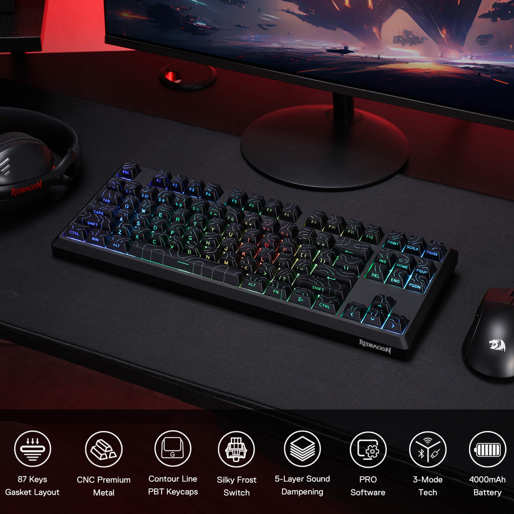 Gaming keyboard on a desk with monitor, mouse, and headset, featuring RGB lighting.
