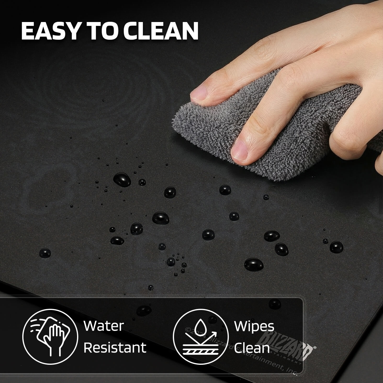 A hand wipes water droplets from the mouse pad with a cloth, highlighting its 'EASY TO CLEAN' feature with 'Water Resistant' and 'Wipes Clean' icons.