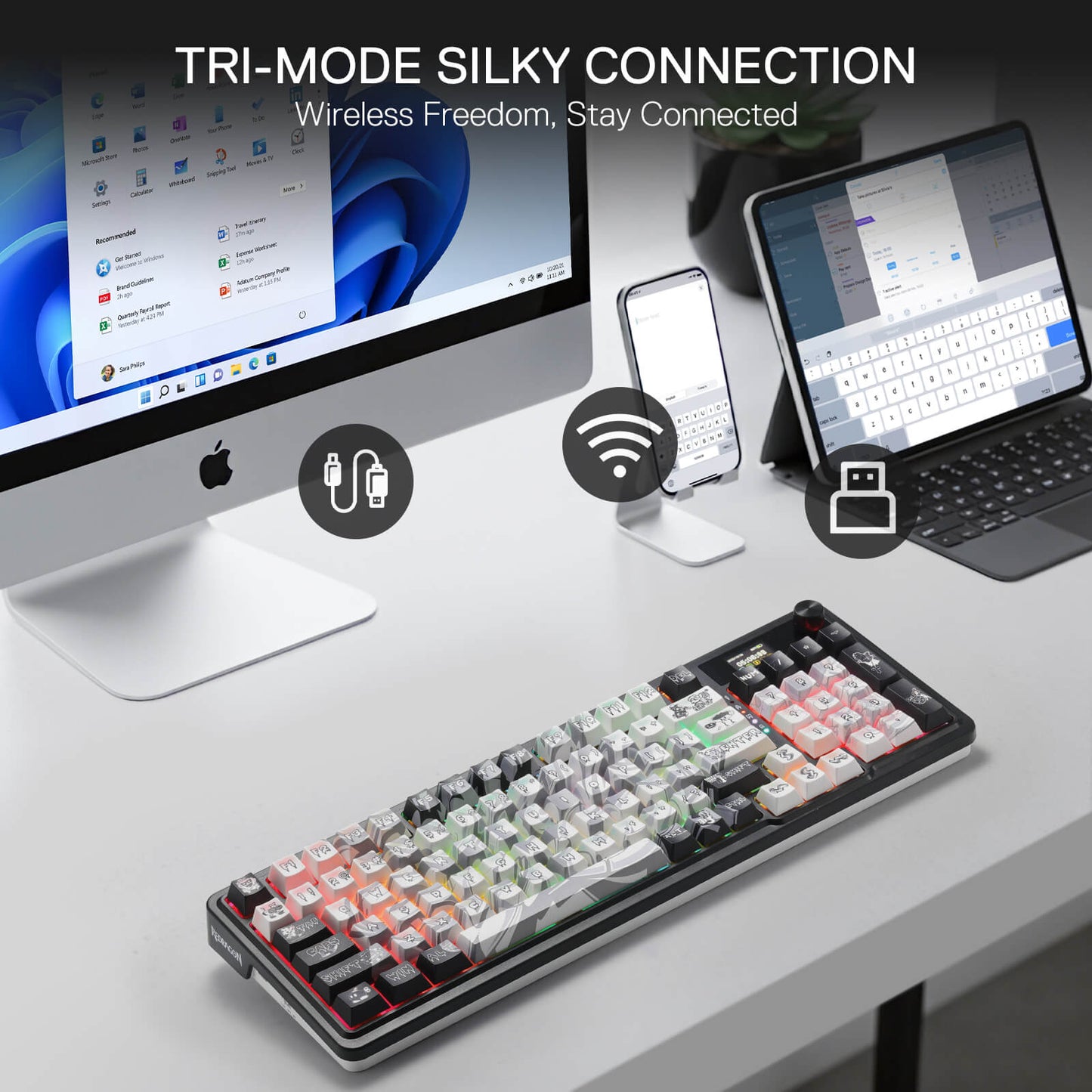 Keyboard with tri-mode connection features displayed on a desk with computer, phone, and tablet.