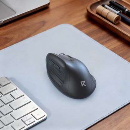 Black mouse on a gray mouse pad with a keyboard and office supplies in the background.