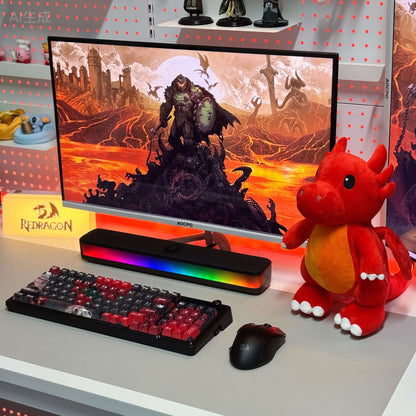Gaming setup with monitor, keyboard, mouse, and plush toy on a desk.