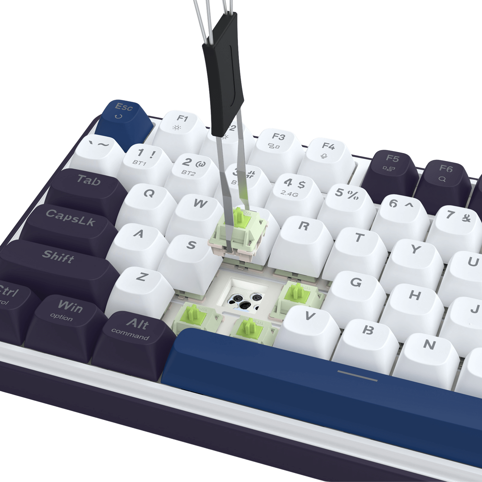 This image shows a keyboard (with white and dark purple keycaps) mid-customization: a tool is removing a green switch from the PCB, highlighting the hot-swap socket design that allows easy switch replacement.
