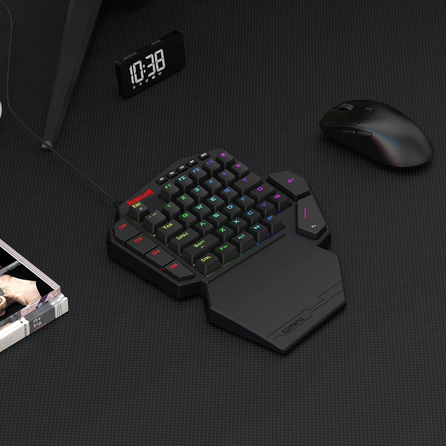 Black ergonomic keyboard with colorful backlighting on a dark surface, next to a mouse and digital clock.