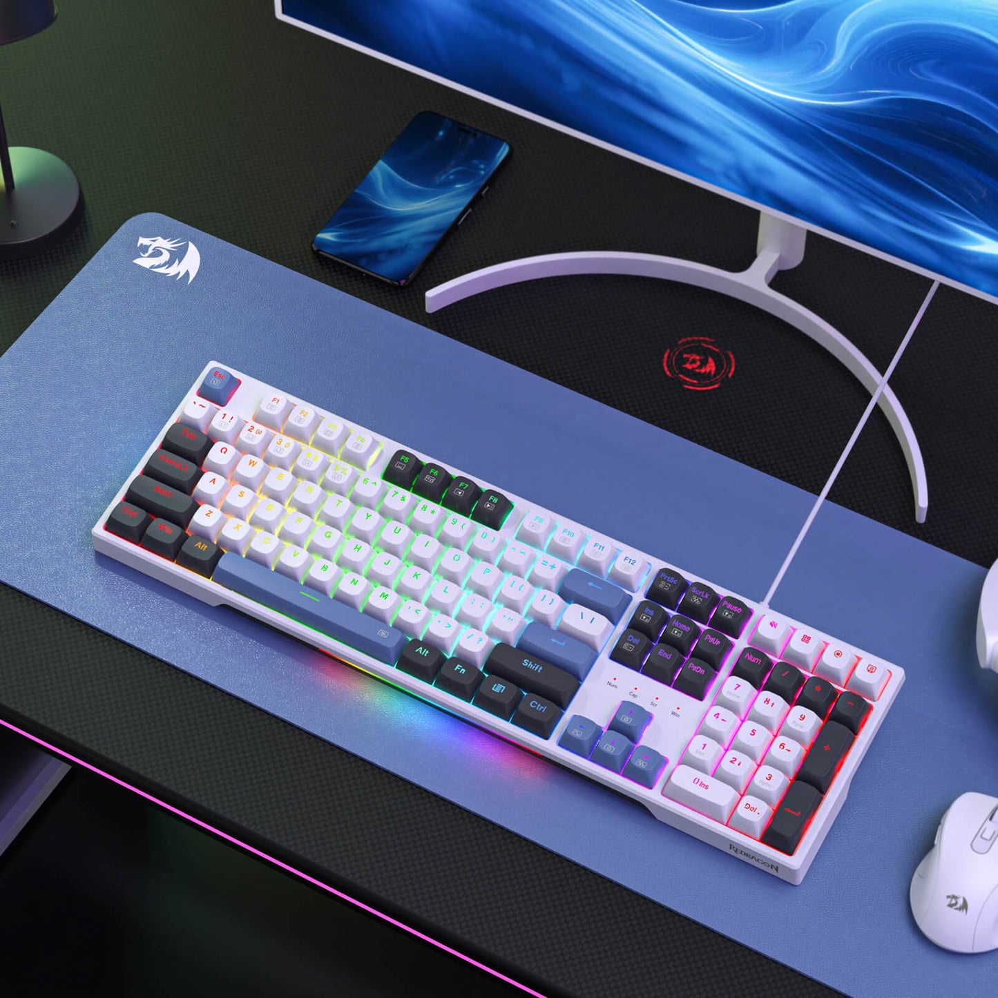Redragon Gaming keyboard on a desk with a monitor, mouse, and phone in the background