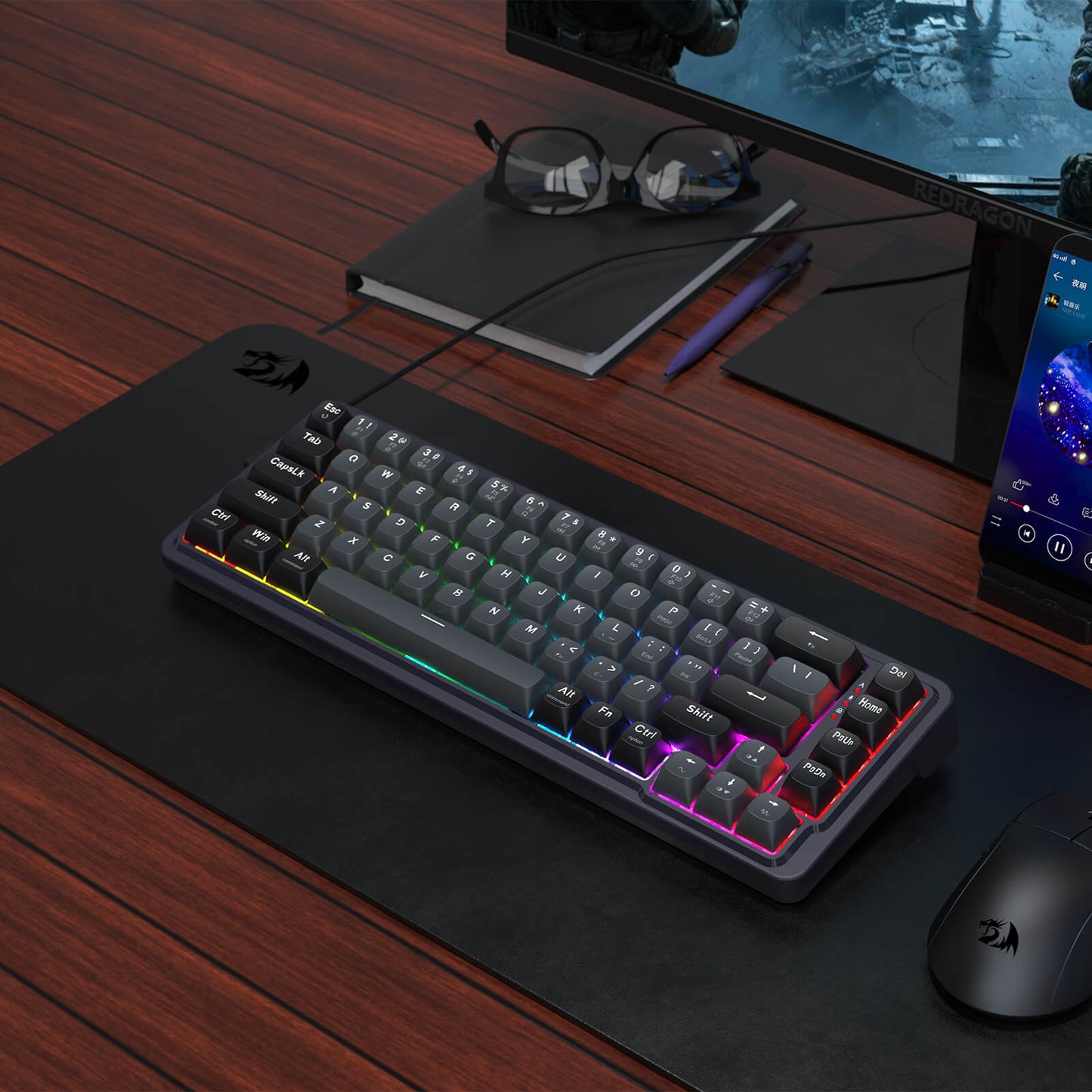 Gaming keyboard with RGB lighting on a desk with a monitor, mouse, and glasses.