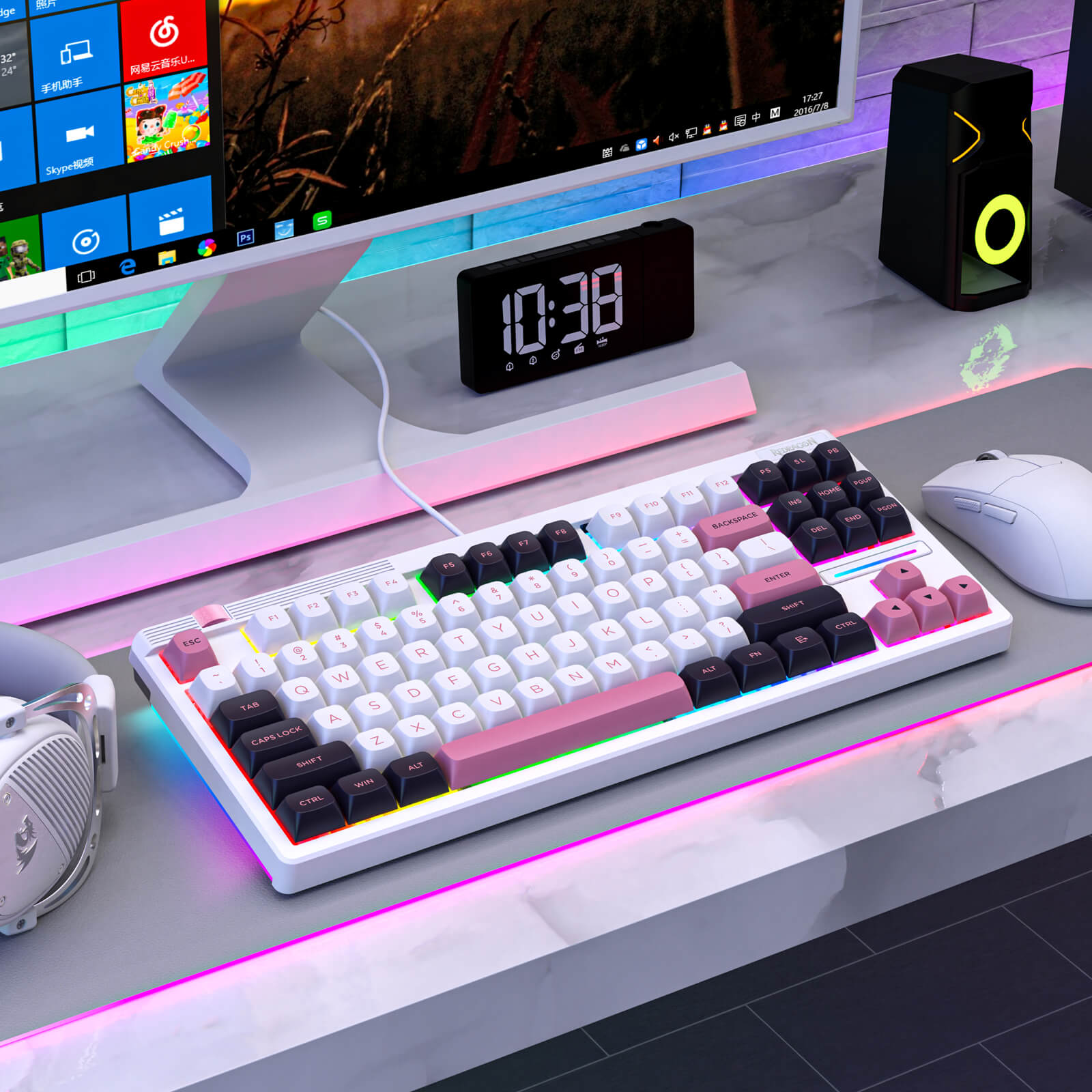 redragon colorful keyboard on a desk with a monitor, clock, and speakers in the background