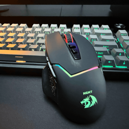Redragon Gaming mouse with RGB lighting in front of a keyboard on a desk