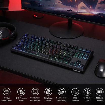 Gaming keyboard on a desk with monitor, mouse, and headset, featuring RGB lighting.