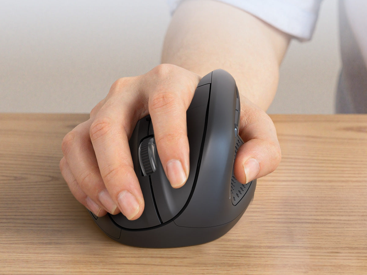 Hand using a black ergonomic mouse on a wooden surface