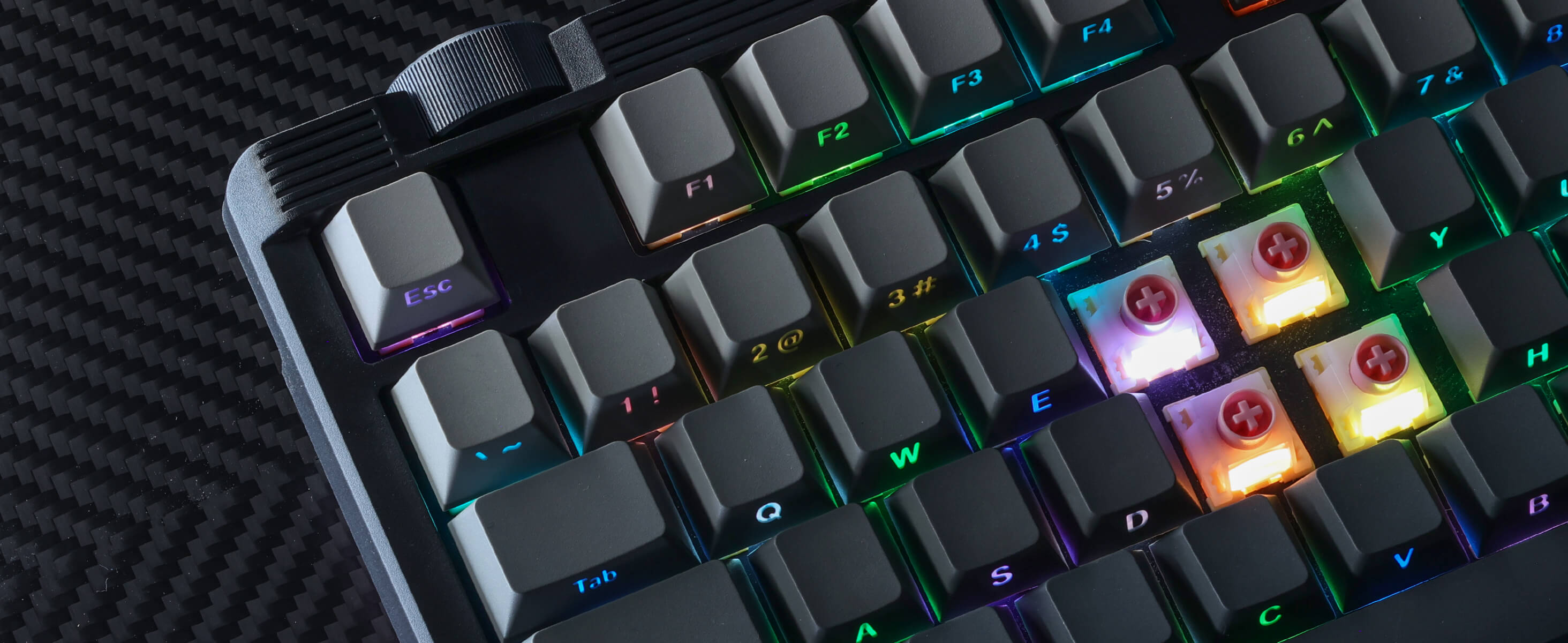 Close-up of a mechanical keyboard with RGB lighting on a textured surface