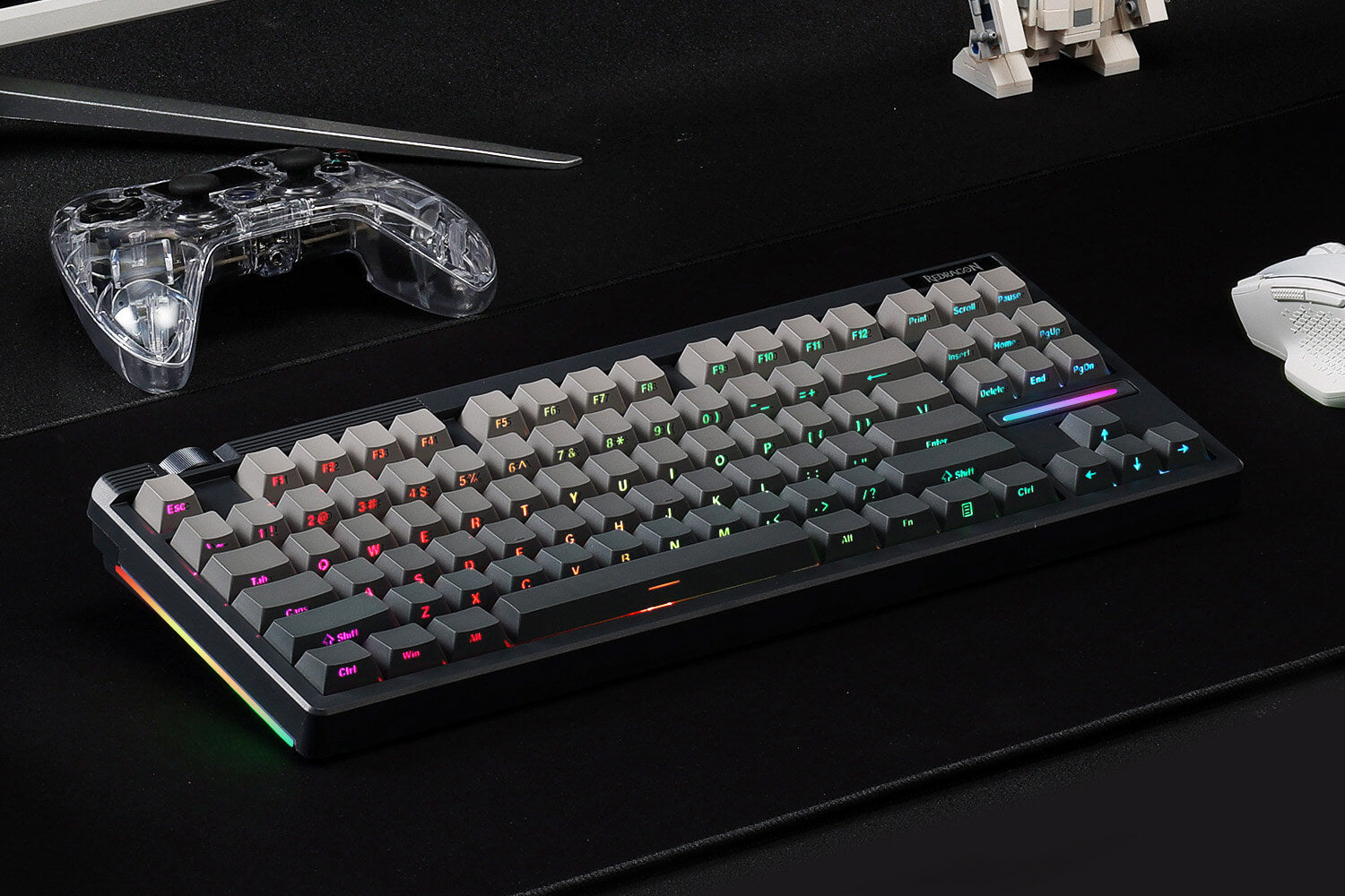 Redragon K729 PRO BLACK Gaming keyboard with RGB lighting on a dark surface with gaming accessories.