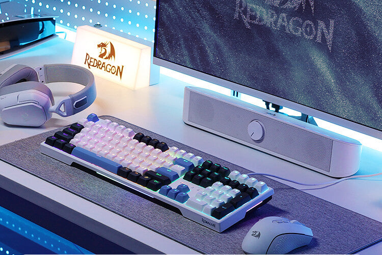 Gaming setup with keyboard, mouse, and monitor featuring Redragon branding.