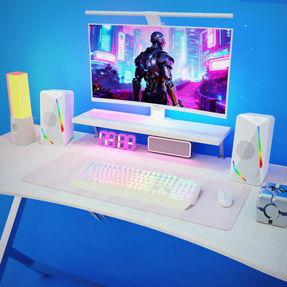 The speakers are shown in a vibrant RGB-lit gaming setup, alongside a mechanical keyboard, mouse, and monitor, enhancing the immersive experience.